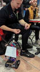 Robot with a sign 'TAKE some Chocolate It's healthy' giving chocolate to foreign participant