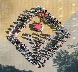 People standing in the shape of the EJOI 2024 logo